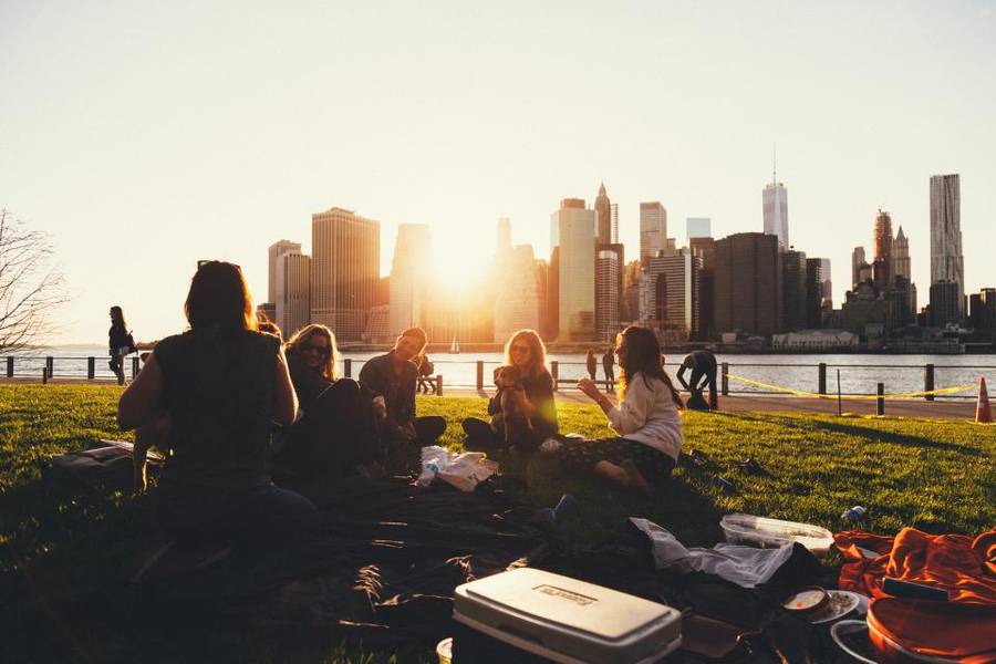 Young friends gathered outdoors with a city skyline behind them