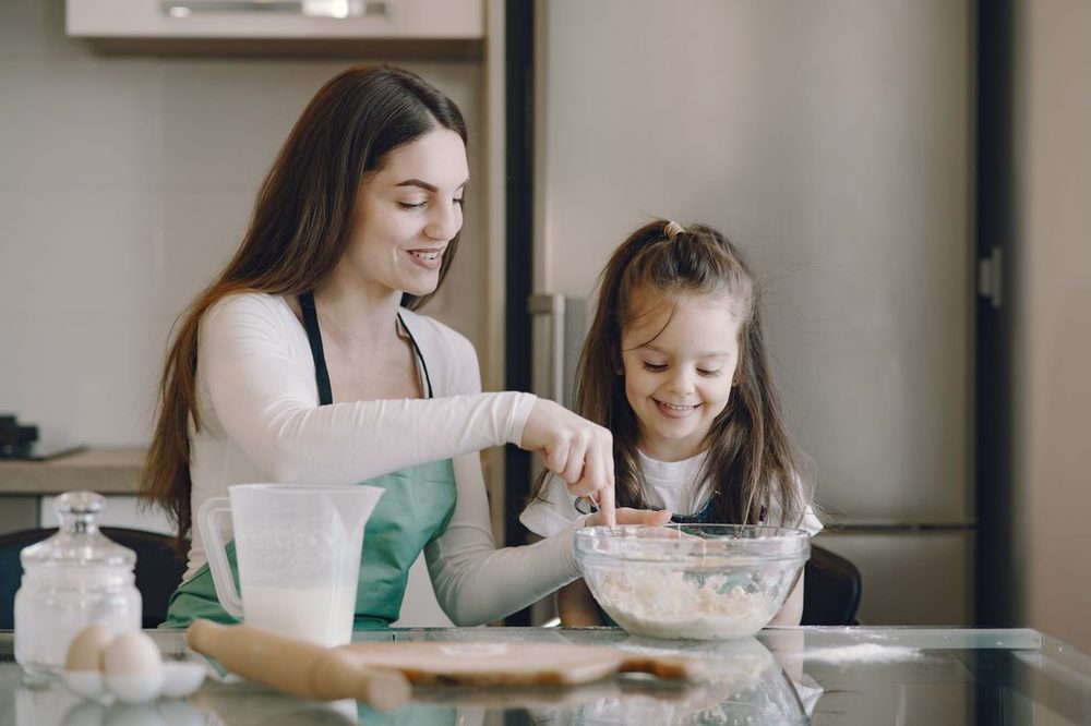A mother and daughter baking together at home