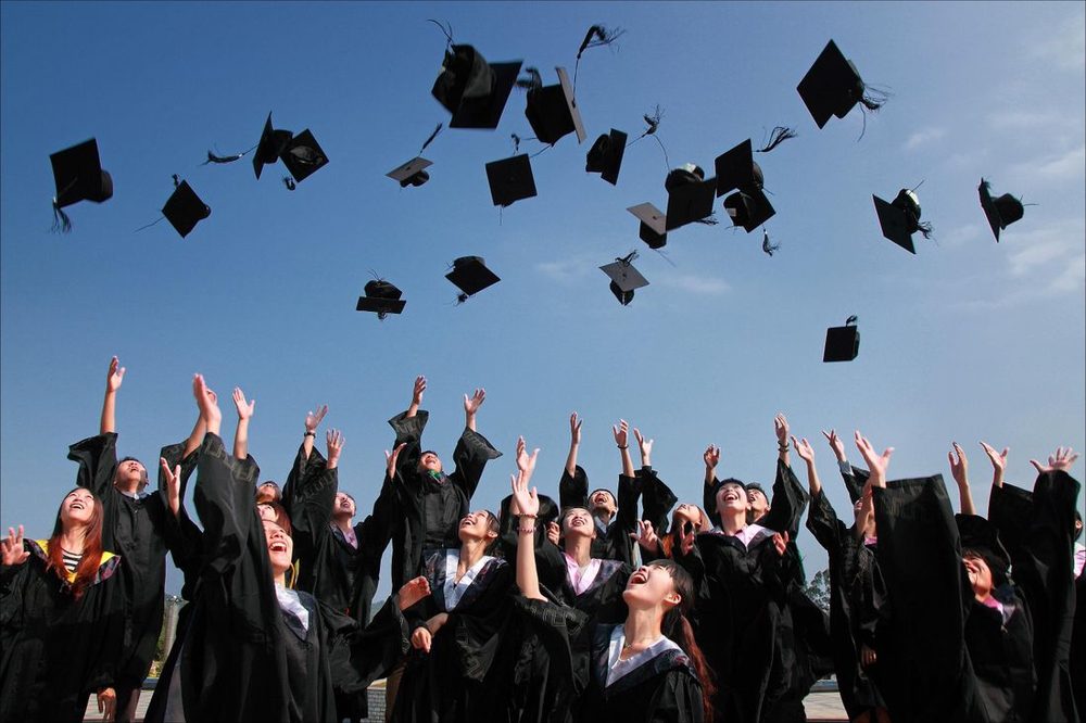 Graduation caps thrown into a clear blue sky